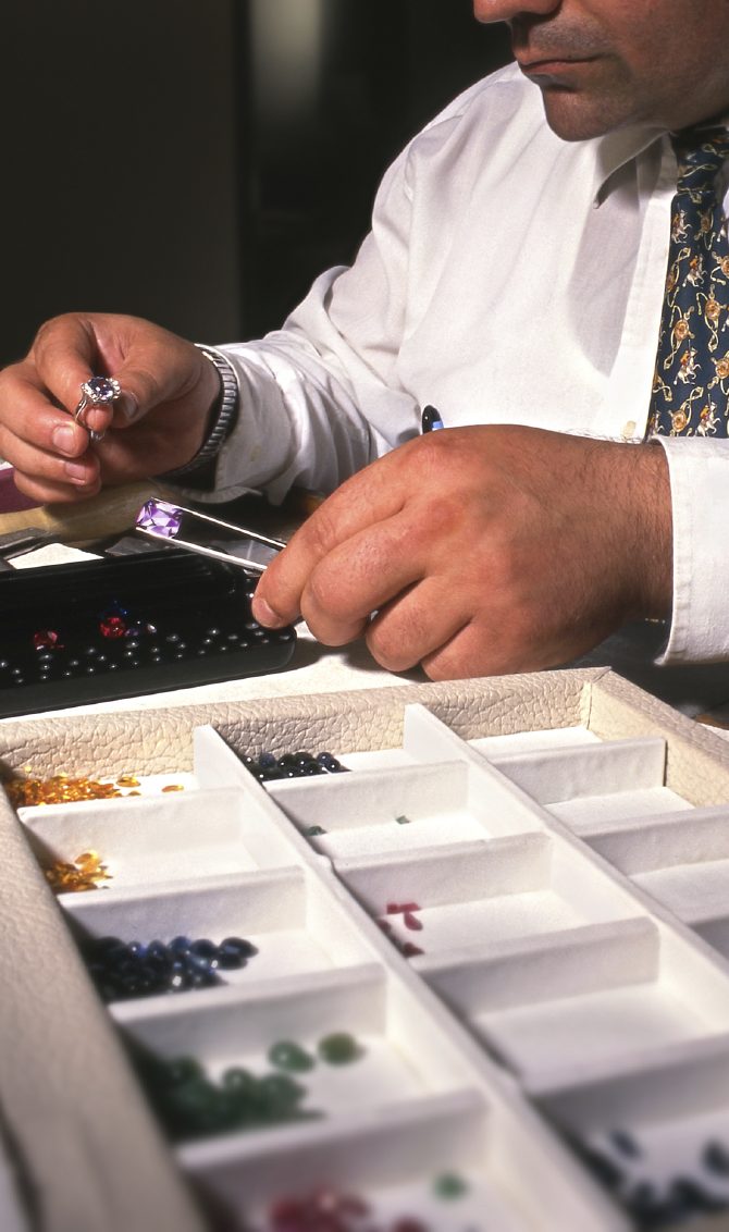 Juwelier sortiert Schmuckstücke und Edelsteine